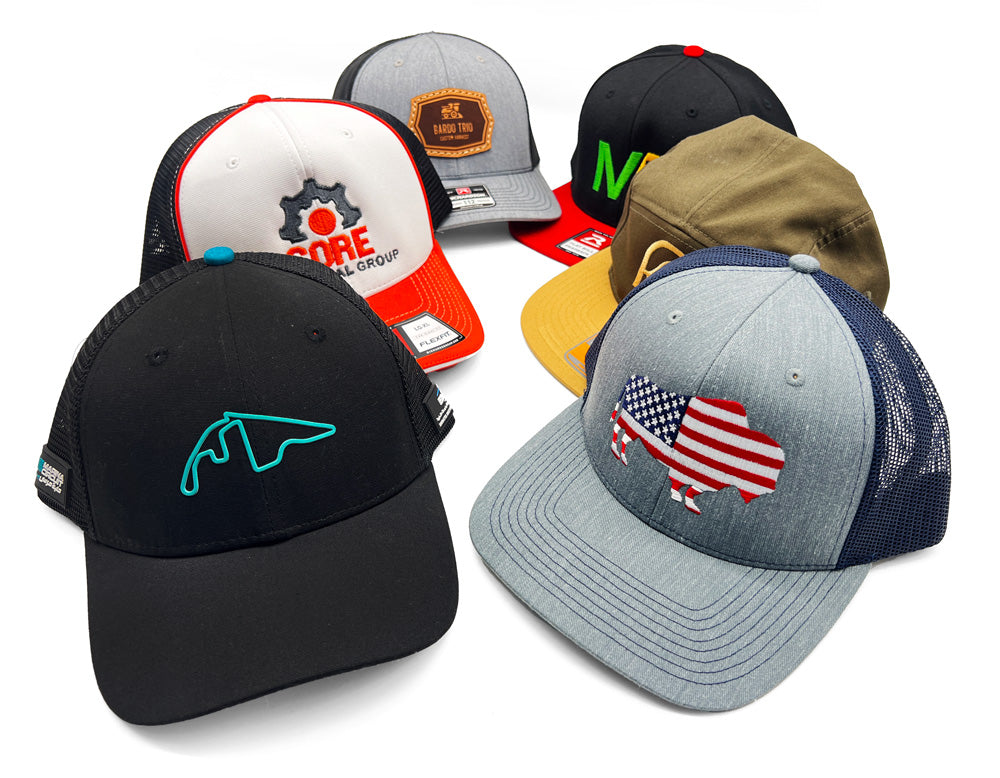 Assortment of six custom-branded caps with various logos, including American flag, in different colors and styles.