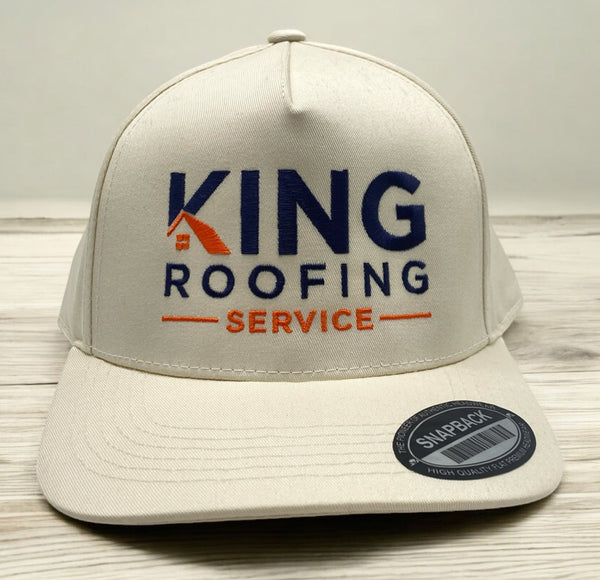 Cream snapback hat with King Roofing Service embroidered in blue and orange