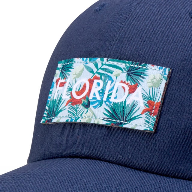 Cap with a woven label reading "FLORIDA" in tropical print on a dark background