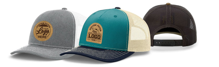 Three two-tone trucker hats with custom patches; colors include gray, teal, and black, each with mesh backs