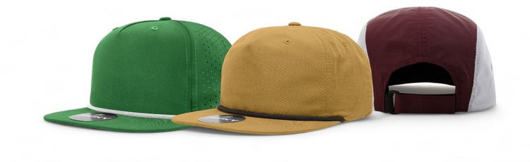 Three 5-panel hats in green, gold, and burgundy, each with distinct detailing and adjustable fit