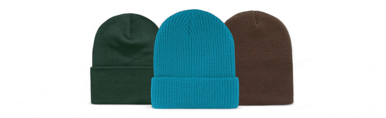 Three knit beanies in dark green, bright teal, and brown, lined up in a row for a simple, stylish look