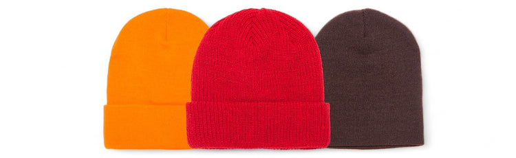 Three colorful knit caps in orange, red, and dark brown, each featuring a cuff and a snug fit