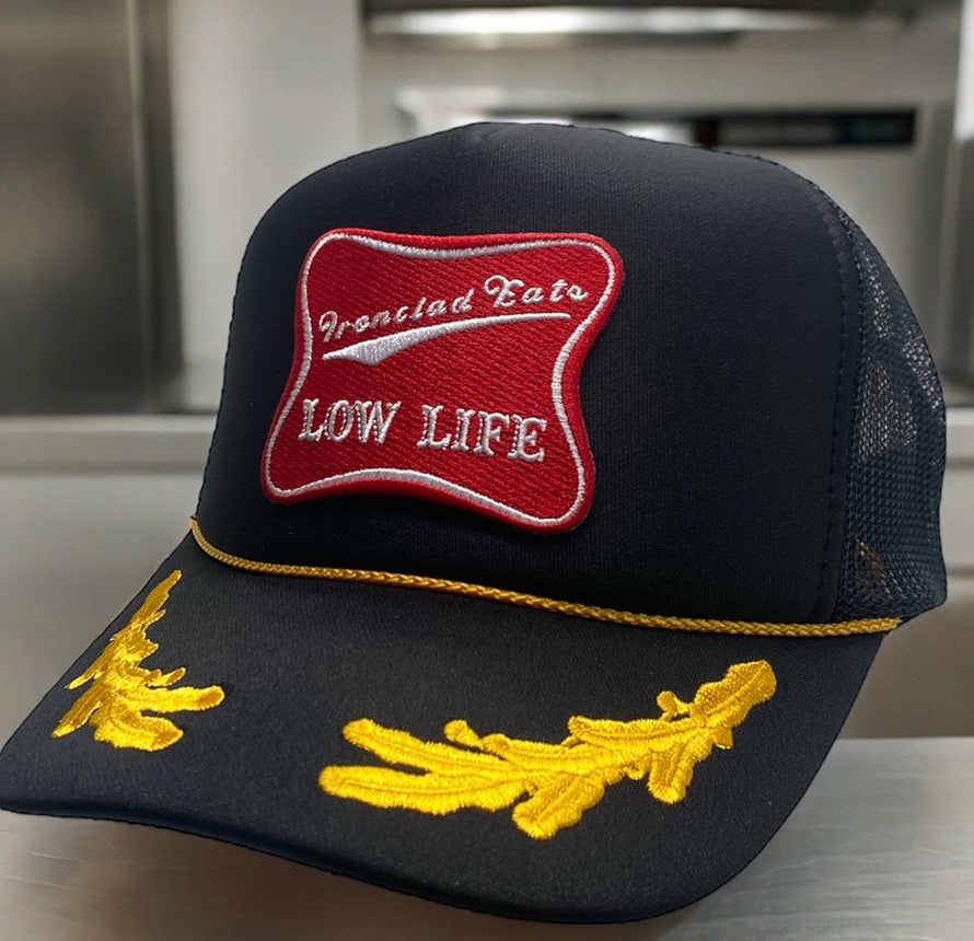 Black hat with 'Low Life' red patch and yellow leaf accents.