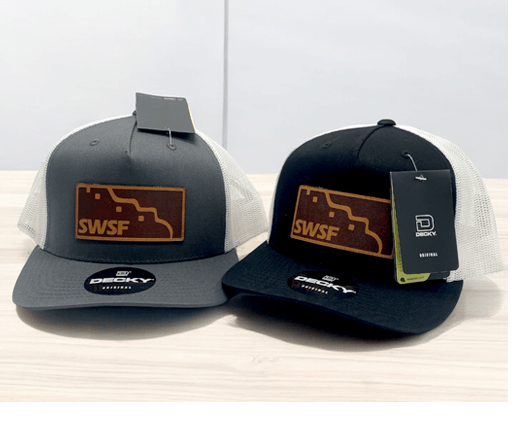 Two Decky trucker hats with white mesh backs and leather 'SWSF' patches, one gray and one black.