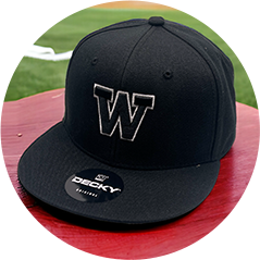 Black baseball cap with a raised 'W' letter, displayed on a red bench at a baseball field