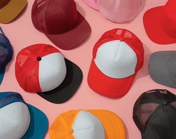 A pink table with a variety of colorful foam trucker hats.