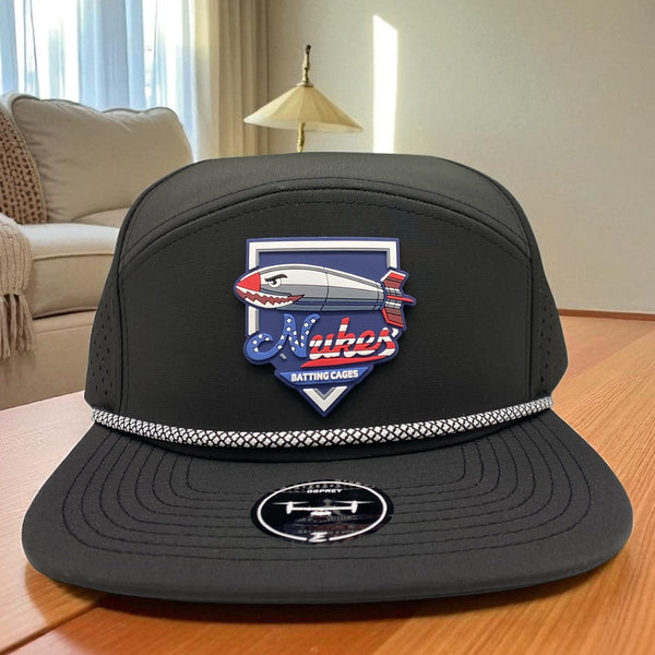 Black Osprey flatbill hat with Nukes Batting Cages logo featuring a red, white, and blue missile design.