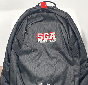 Black SGA Gymnastics backpack with red and white logo