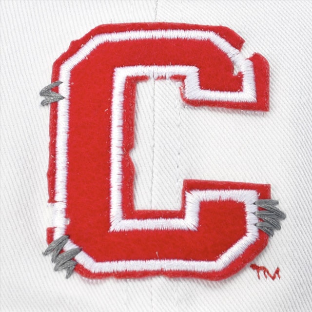 Close-up of a red felt letter "C" with white trim and silver nailhead on white fabric